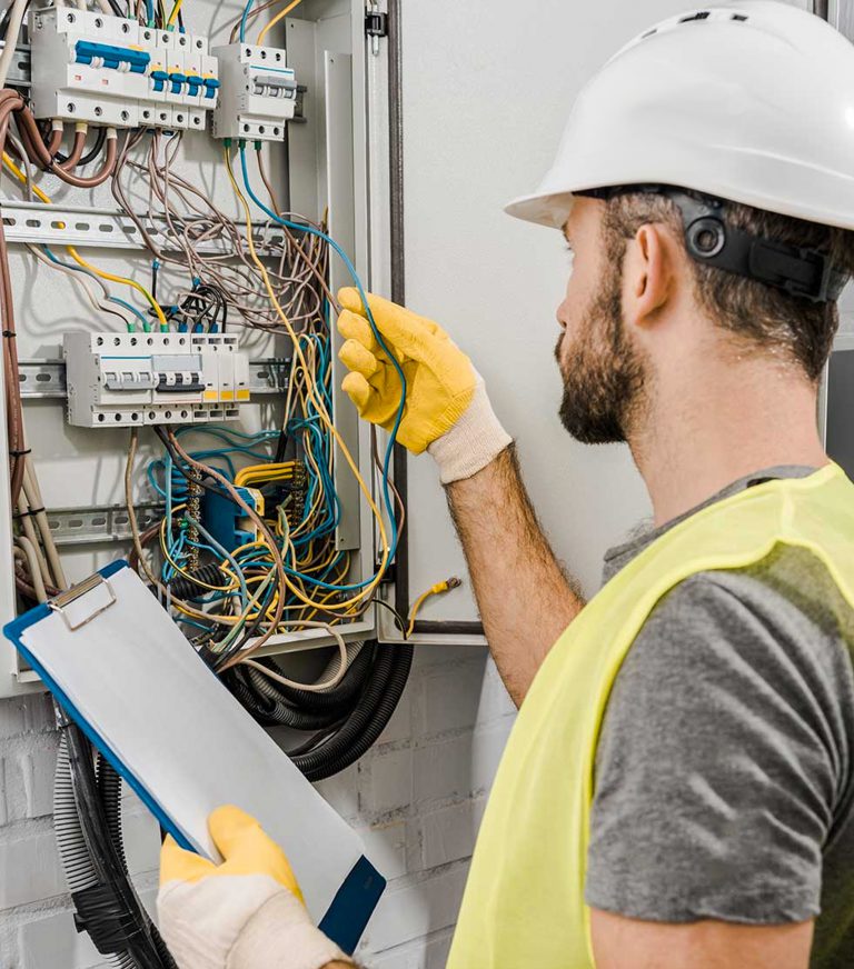 An Electrician or Electrical Contractor working on a panel.